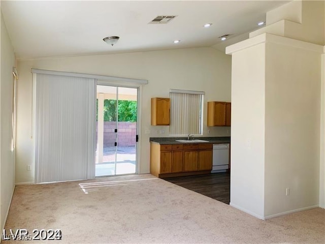 kitchen featuring vaulted ceiling, white dishwasher, dark carpet, and sink