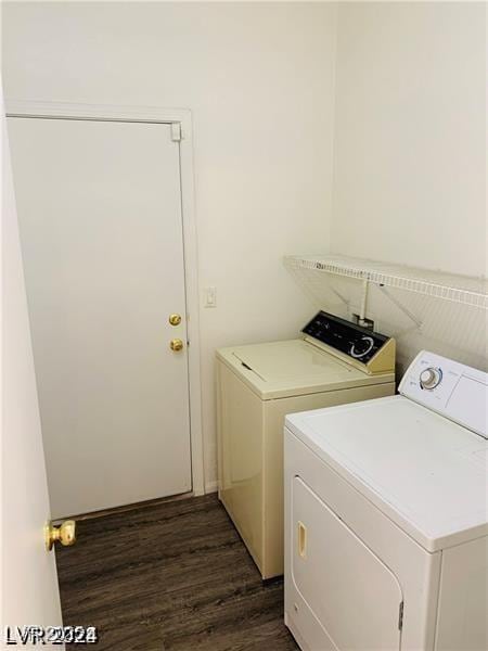 laundry area featuring washer and clothes dryer and dark wood-type flooring