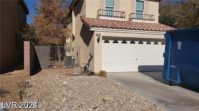 view of home's exterior featuring central AC, a balcony, and a garage