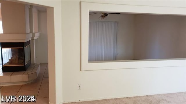 interior details featuring ceiling fan and a fireplace