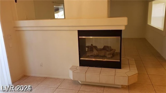 interior details featuring a tile fireplace