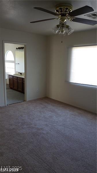 spare room with ceiling fan, sink, and light carpet