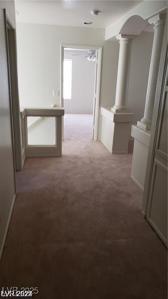 hallway featuring carpet flooring and ornate columns