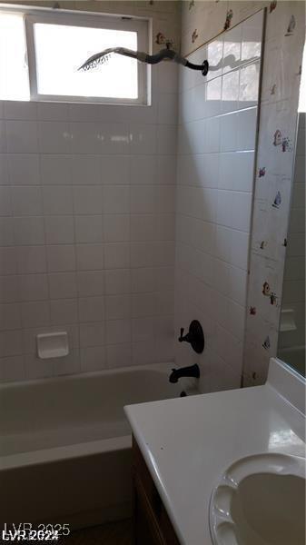 bathroom featuring vanity and tiled shower / bath