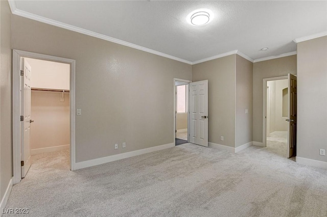 unfurnished bedroom with a walk in closet, light colored carpet, a closet, and ornamental molding