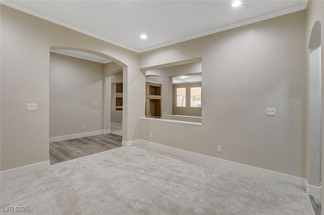 empty room with light colored carpet and crown molding