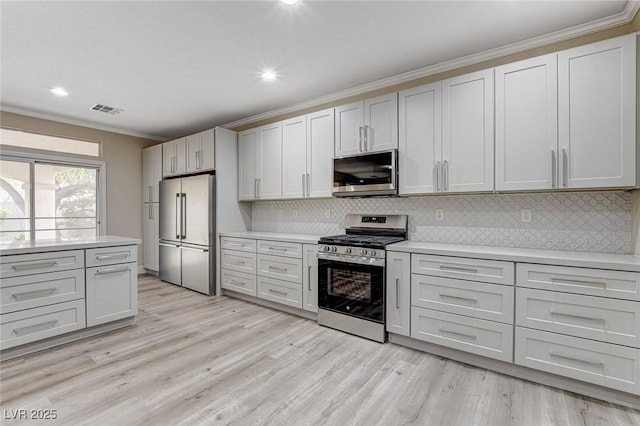 kitchen featuring decorative backsplash, light hardwood / wood-style floors, crown molding, and appliances with stainless steel finishes