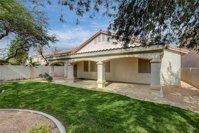 back of house with a patio area and a yard