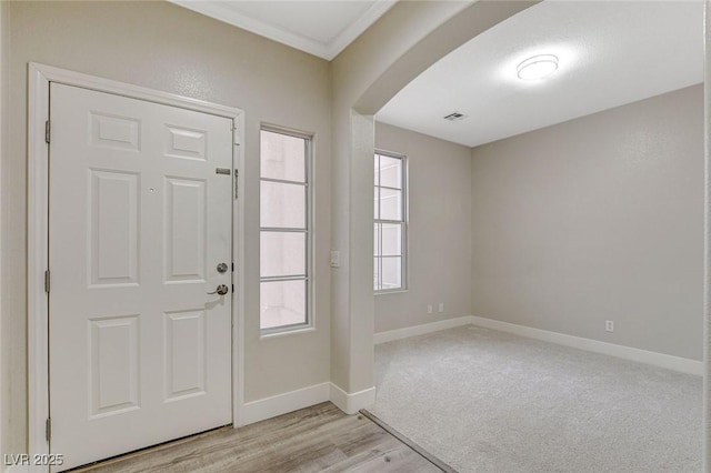 foyer entrance featuring light hardwood / wood-style flooring and ornamental molding