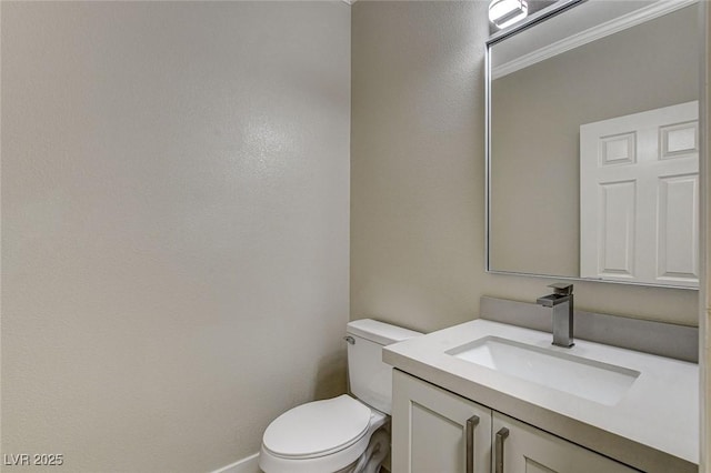 bathroom featuring vanity, toilet, and crown molding