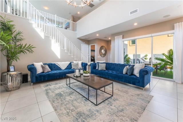 tiled living room featuring a high ceiling and a chandelier