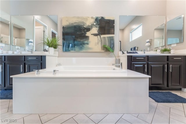 bathroom featuring vanity, tile patterned floors, and a tub