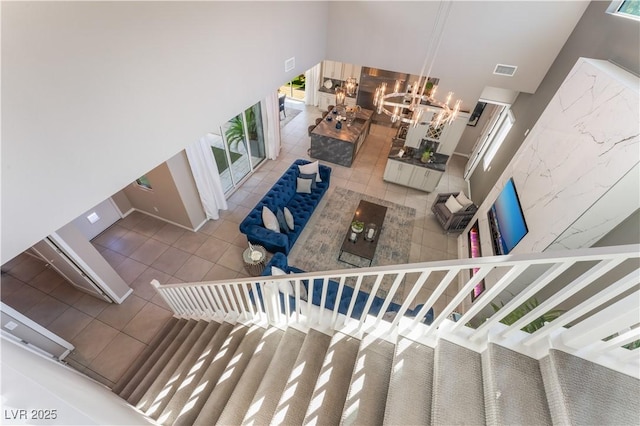 staircase with an inviting chandelier and tile patterned floors