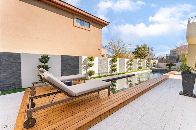 wooden terrace featuring a patio and a fenced in pool