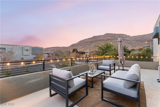 patio terrace at dusk with an outdoor hangout area and a mountain view