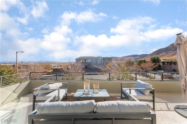 view of patio / terrace with a balcony, an outdoor living space, and a mountain view