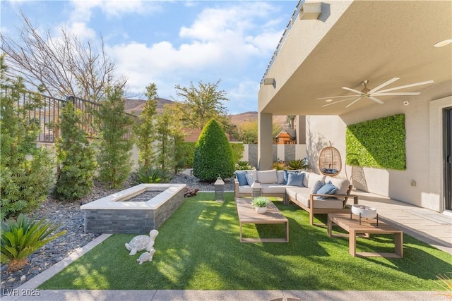 view of yard featuring an outdoor living space with a fire pit, ceiling fan, and a patio area