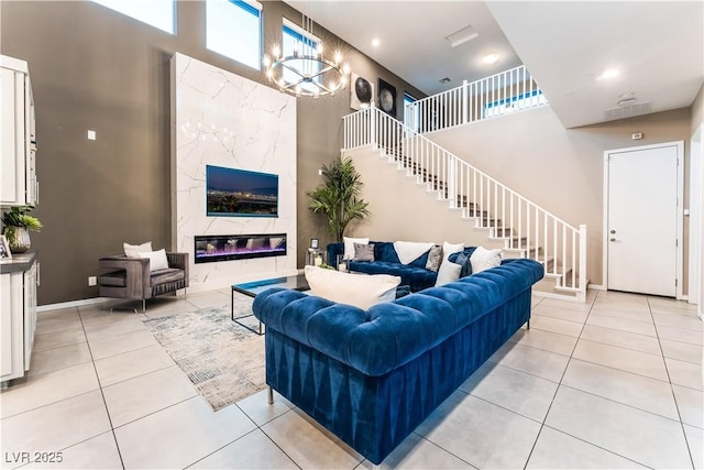 tiled living room with a premium fireplace and an inviting chandelier