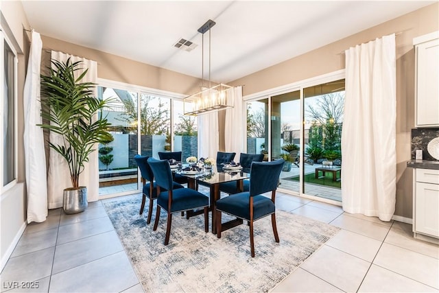 tiled dining room with an inviting chandelier and a wealth of natural light