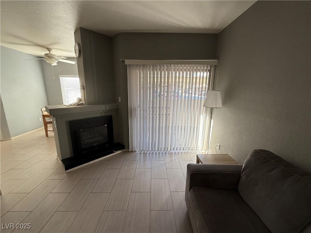 living room featuring a textured ceiling, ceiling fan, and lofted ceiling