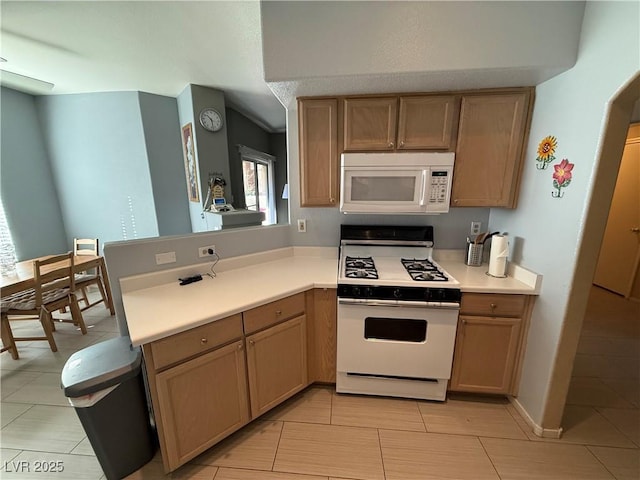 kitchen featuring kitchen peninsula, light tile patterned floors, and white appliances