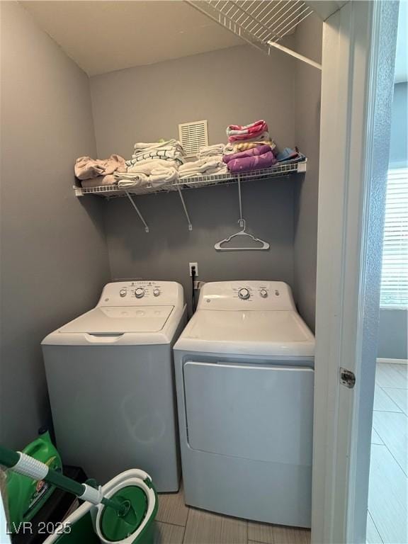 clothes washing area with washer and clothes dryer