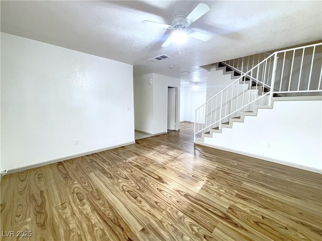 interior space with hardwood / wood-style flooring, ceiling fan, and a textured ceiling