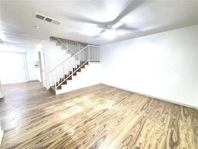 unfurnished room featuring hardwood / wood-style floors, ceiling fan, and a textured ceiling