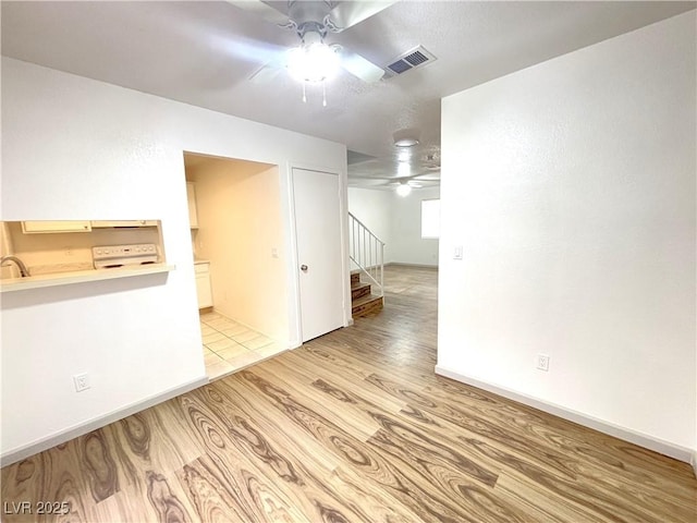 spare room featuring ceiling fan, sink, and light hardwood / wood-style flooring