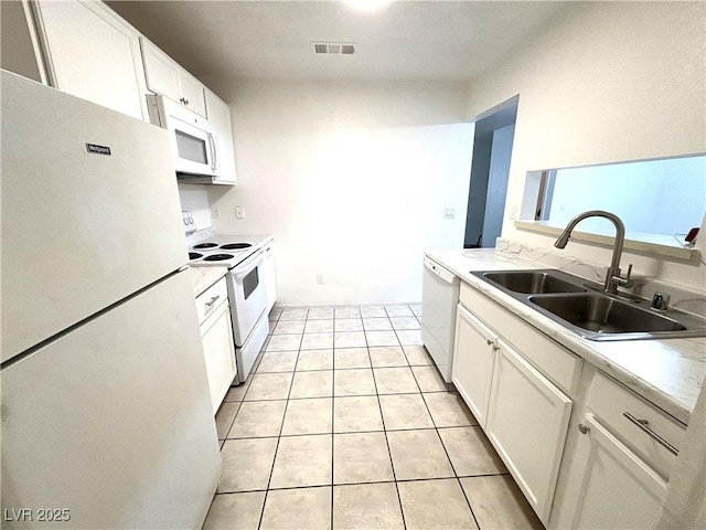 kitchen featuring light tile patterned floors, white appliances, white cabinetry, and sink