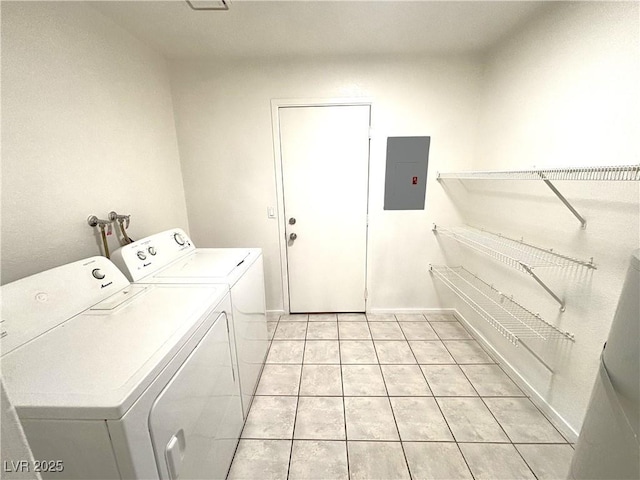 washroom with light tile patterned floors, washing machine and dryer, and electric panel