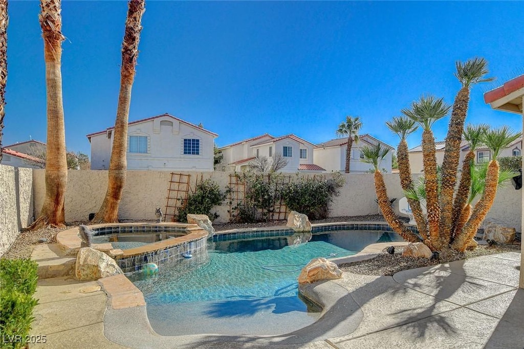 view of swimming pool with an in ground hot tub