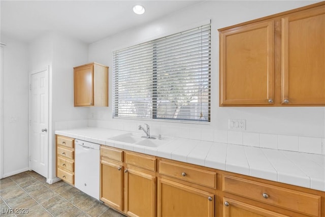 kitchen featuring tile counters, dishwasher, and sink