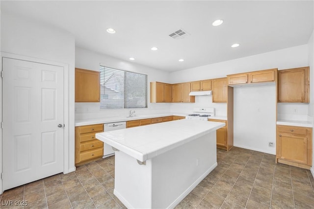 kitchen featuring sink, a kitchen island, and white appliances