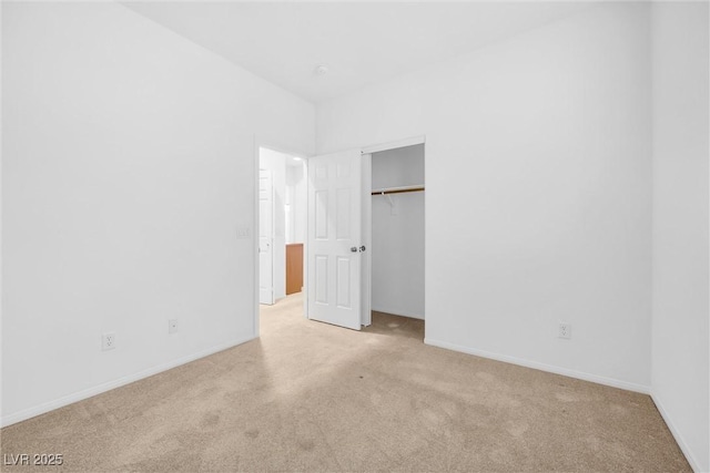 unfurnished bedroom with light carpet and a closet