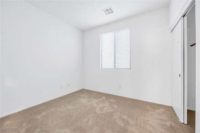 unfurnished bedroom with a closet and light colored carpet