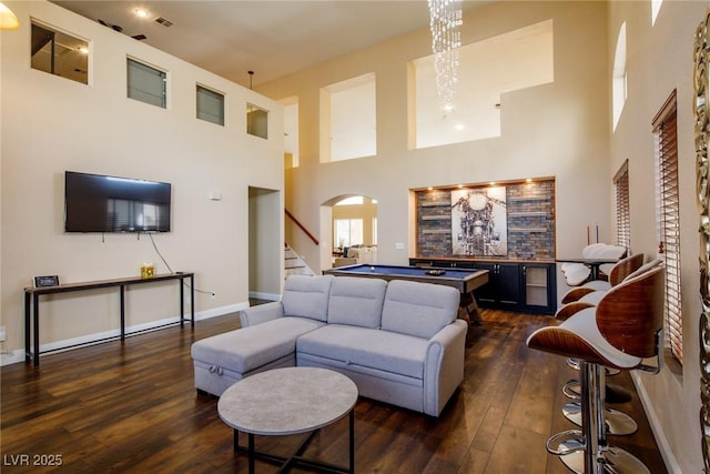 living room with dark hardwood / wood-style floors, a high ceiling, and a notable chandelier