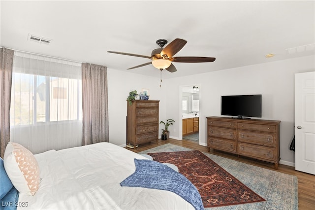 bedroom featuring ceiling fan, connected bathroom, and light wood-type flooring