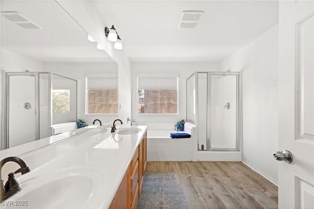 bathroom featuring wood-type flooring, plus walk in shower, and vanity