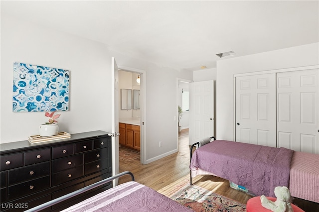 bedroom featuring light hardwood / wood-style floors, a closet, and ensuite bathroom