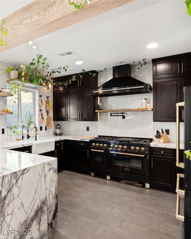 kitchen with wall chimney exhaust hood, sink, tasteful backsplash, and stainless steel appliances