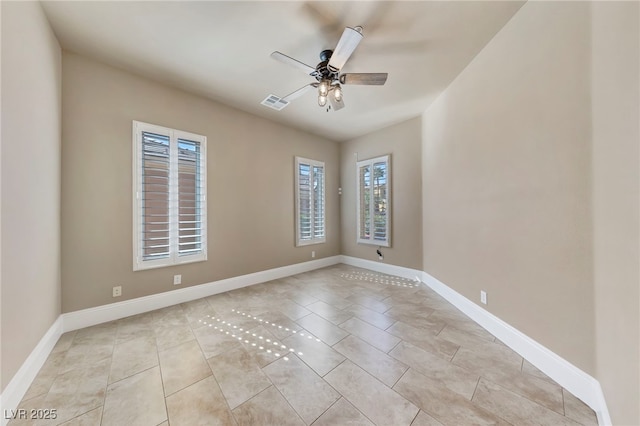 tiled spare room featuring ceiling fan