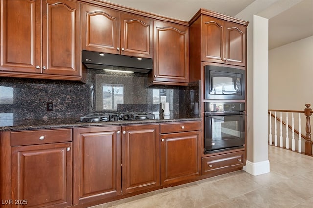 kitchen with tasteful backsplash, dark stone countertops, light tile patterned floors, and black appliances