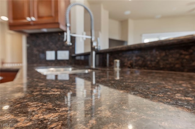 room details featuring tasteful backsplash and dark stone counters