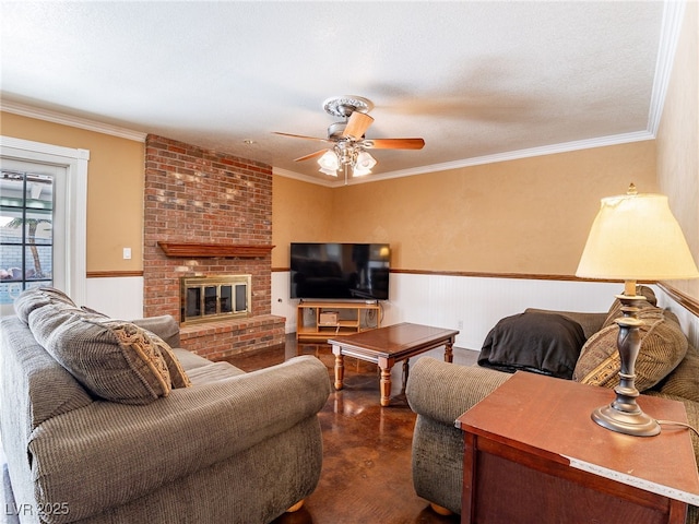 living room featuring ceiling fan, a fireplace, a textured ceiling, and ornamental molding