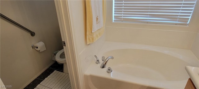 bathroom featuring tile patterned flooring, toilet, and a bathtub