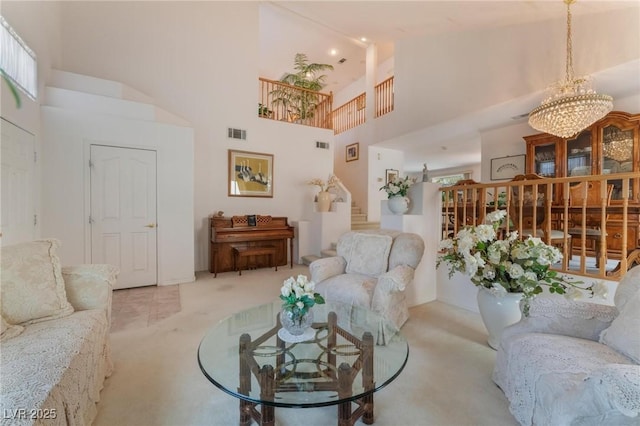 carpeted living room featuring a chandelier and a high ceiling