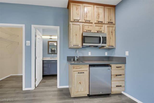 kitchen with light brown cabinets, stainless steel appliances, dark wood-type flooring, and sink