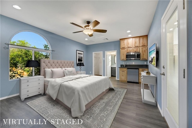 bedroom with connected bathroom, hardwood / wood-style flooring, and ceiling fan