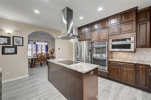 kitchen featuring island exhaust hood, ornamental molding, dark brown cabinetry, stainless steel appliances, and a center island